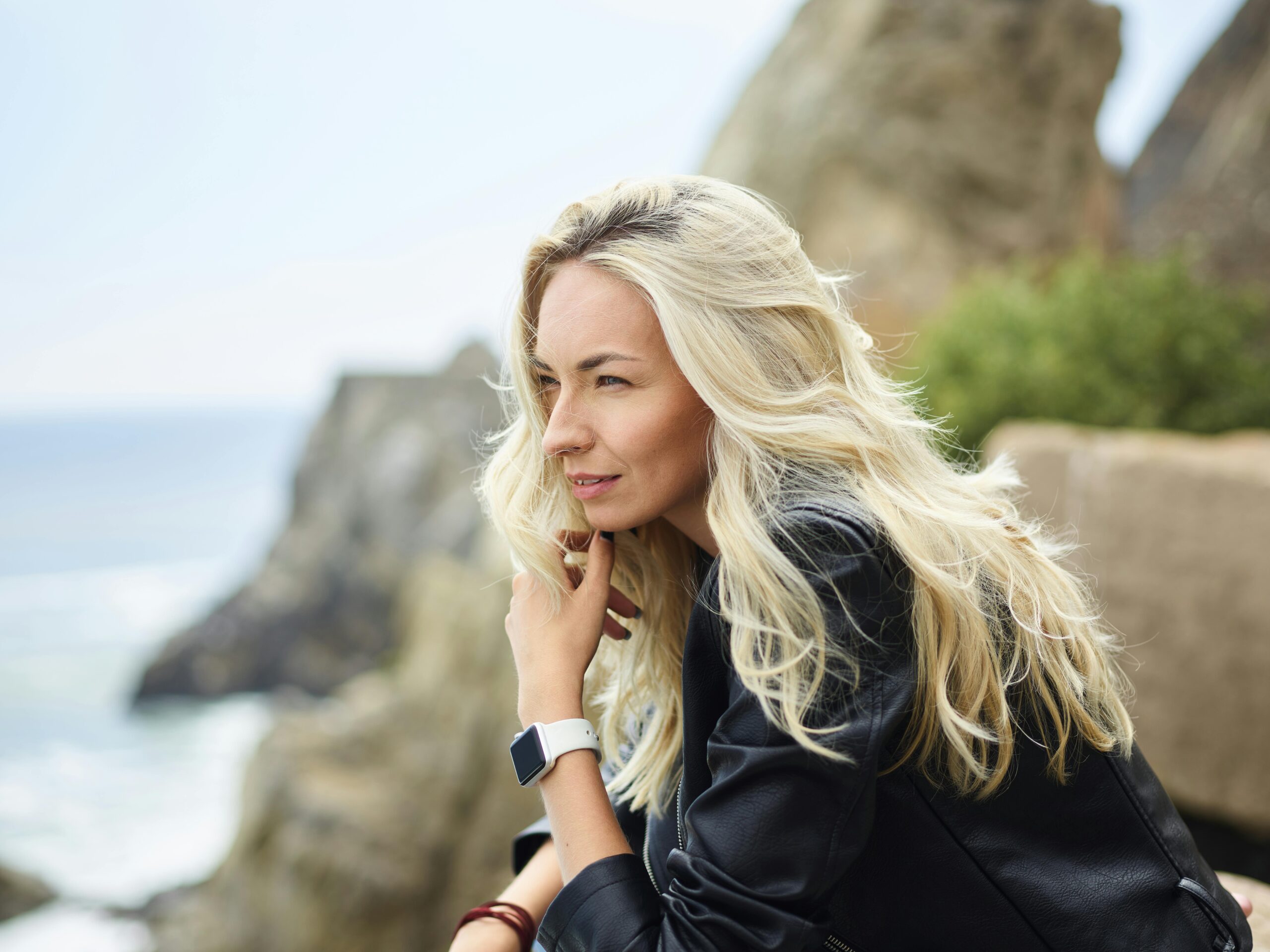 Young woman meditating on top of cliff